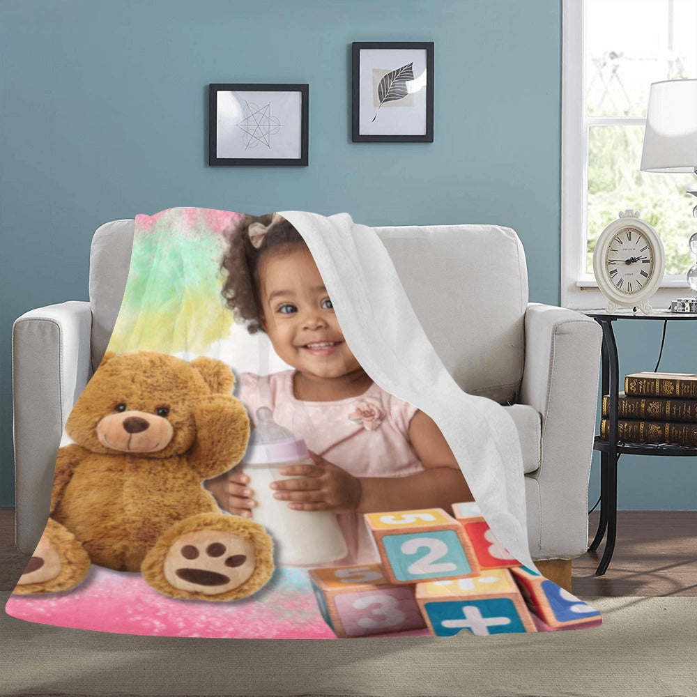 Child with teddy bear and blocks on a colorful blanket in a cozy living room.